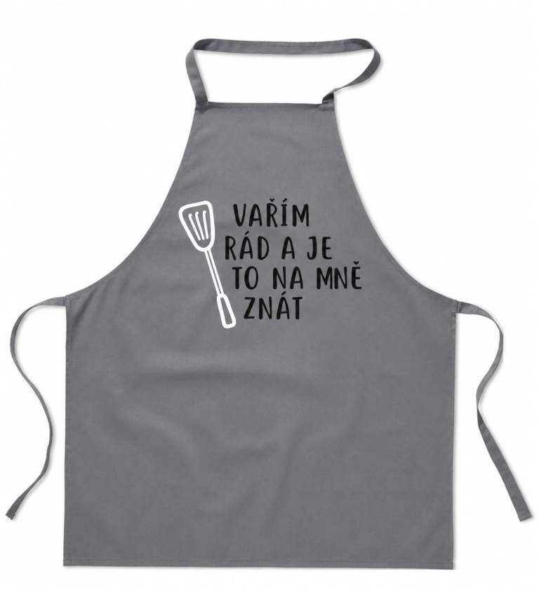 Šedá zástěra s nápisem Vařím rád a je to na mě znát